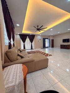 a living room with a couch and a ceiling fan at De'Lunar Homestay in Johor Bahru