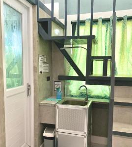 a kitchen with a sink and a spiral staircase at Natos Residences - Gonzaga in Bacolod +87 photos