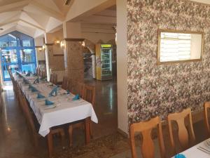 a dining room with tables and chairs and a floral wall at Hotel Split in Usora