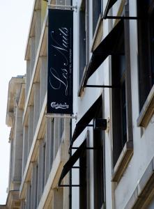 a black sign on the side of a building at Hotel Les Nuits in Antwerp