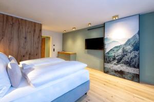 a bedroom with two beds and a large painting on the wall at eva,GARDEN in Saalbach-Hinterglemm