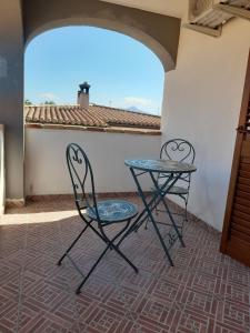 two chairs and a table on a patio at Casa Grazia Deledda 16 in Orosei