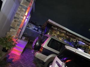 a white suv parked outside of a house at night at Binyuma Suites Motel in Kampala
