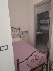 a small bedroom with a bed and a bathroom at Casa Grazia Deledda 16 in Orosei