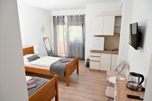 a small bedroom with two beds and a kitchen at Sobe i apartmani MILLA in Slavonski Brod