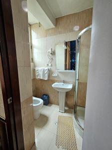 a bathroom with a sink and a toilet and a shower at C Fun Addis Hotel in Addis Ababa +18 photos