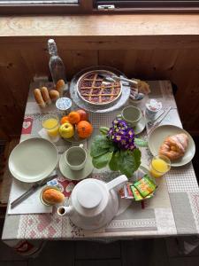 a table with breakfast foods and a teapot at Artemisia Eco-Pet friendly B&B in La Salle