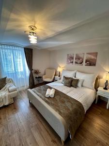 a large bedroom with a large bed and a chair at Petőfi Sarok Apartman in Keszthely