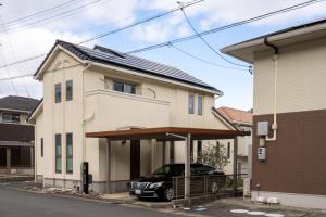 a house with a car parked in front of it at ISE Resort 綾 UZ1 in Ise