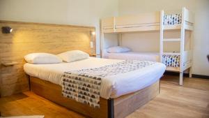 a bedroom with a bed and bunk beds at my HOTEL Bordeaux in Artigues-près-Bordeaux