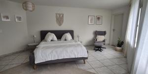 a bedroom with a large bed and a chair at Moderne Gästesuite in Lucerne