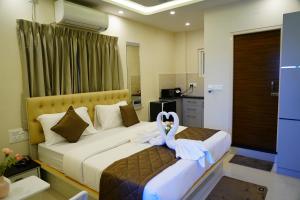 a hotel room with a bed with a swan on it at Deva Towers in Puttaparthi +21 photos