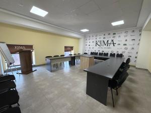 a conference room with tables and chairs and a wall at KUMA Hotel Gyumri in Gyumri