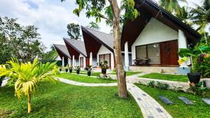 a house with a green lawn in front of it at Pearl Villa Katunayake in Katunayaka