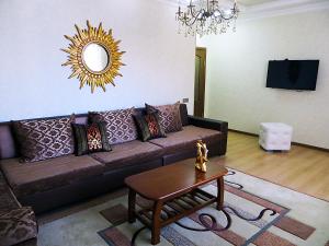 a living room with a brown couch and a table at Best-BishkekCity Apartments 2 in Bishkek