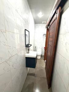 a white bathroom with a sink and a toilet at Lestari Homestay Jimbaran in Jimbaran +17 photos