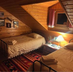 a bedroom with two beds in a log cabin at Vytina log house in Vitina +22 photos