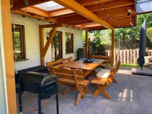 a patio with a grill and a table and chairs at Auszeit Ferienhaus Nr 2 und 2a in Sierscheid