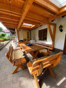 a picnic table and chairs under a wooden roof at Auszeit Ferienhaus Nr 2 und 2a in Sierscheid