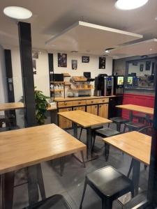 a restaurant with wooden tables and chairs in a room at my HOTEL Bordeaux in Artigues-près-Bordeaux +48 photos