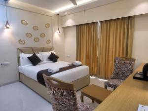 a hotel room with a bed and a table and a desk at Ammora Resort in Kārli