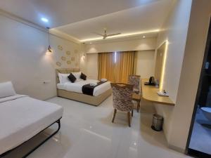 a hotel room with a bed and a desk at Ammora Resort in Kārli +1 photo