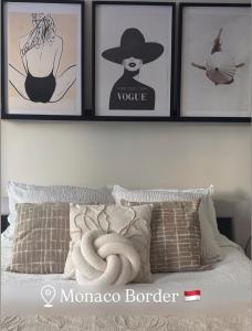 a bedroom with four pictures on the wall and a bed at L'Ecrin de Monaco Studio Emplacement privilégié in Beausoleil