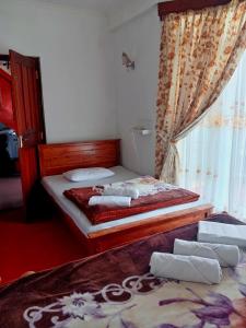 a bedroom with two beds and a window at Ragith Villa in Nuwara Eliya