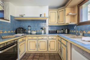 a kitchen with yellow cabinets and blue tiles at Chalet Cusco in Servoz