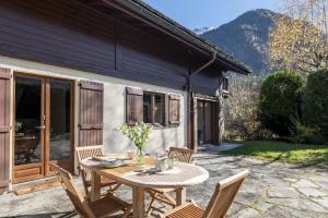 a patio with a table and chairs in front of a house at Chalet Cusco in Servoz
