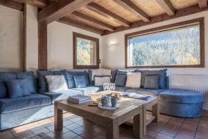 a living room with a blue couch and a table at Chalet Cusco in Servoz