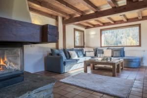 a living room with a couch and a fireplace at Chalet Cusco in Servoz +22 photos