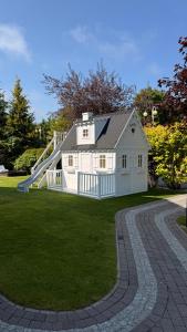 a white house with a slide in a yard at Rosa Park in Rowy