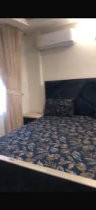 a bedroom with a bed with a blue comforter at Luxury Aparment in Islamabad