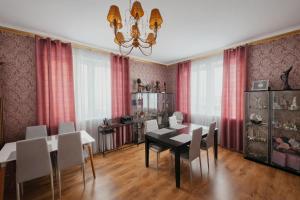 a dining room with a table and chairs and a chandelier at Family Hotel Daugavpils in Daugavpils