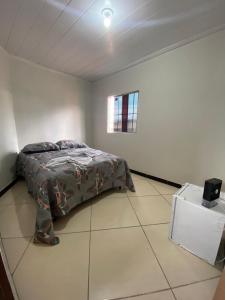 a bedroom with a bed and a small window at Flets Triunfo-PE in Triunfo