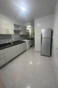 a kitchen with a stainless steel refrigerator in it at Aconchego na praia in Ilhéus