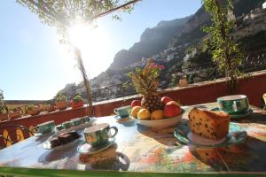 a table with a bowl of fruit on a balcony at Princely Houses in Positano