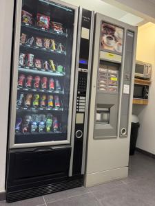 a vending machine with soda cans in a kitchen at my HOTEL Bordeaux in Artigues-près-Bordeaux