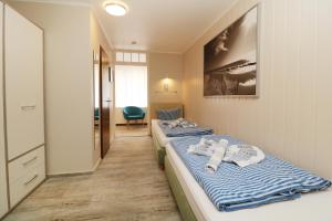 a room with two beds and a chair in it at Koserow Hotel Wald und Meer in Koserow