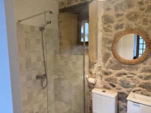 a bathroom with a shower with a toilet and a mirror at El Escondite Inglés in Pantón +22 photos