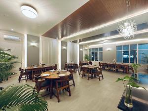 a restaurant with wooden tables and chairs and a chandelier at Hotel Tragopan in Dimāpur