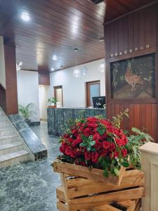 a lobby with a large display of red flowers at Hotel Tragopan in Dimāpur