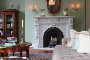a living room with a fireplace and a couch at Schlosshotel Burg Schlitz in Hohen Demzin