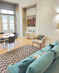 a living room with a blue couch and a table at Romantic Douro River & Sunset views in Porto