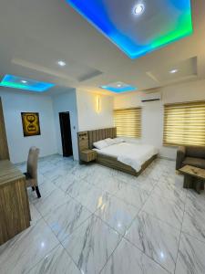 ein Schlafzimmer mit einem Bett, einer Couch und einem Tisch in der Unterkunft Stan - Haven Apartments ASOKORO in Asokoro