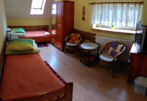 Habitación con cama, sillas y TV. en Ośrodek Wypoczynku Natura w Nałęczowie en Nałęczów