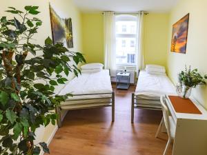 a room with two beds and a potted plant at Attic apartment in villa! in Berlin