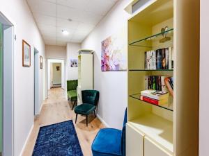 a hallway with a chair and a book shelf at Attic apartment in villa! in Berlin