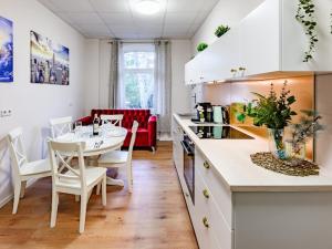 a kitchen with a table and a dining room at Attic apartment in villa! in Berlin +8 photos